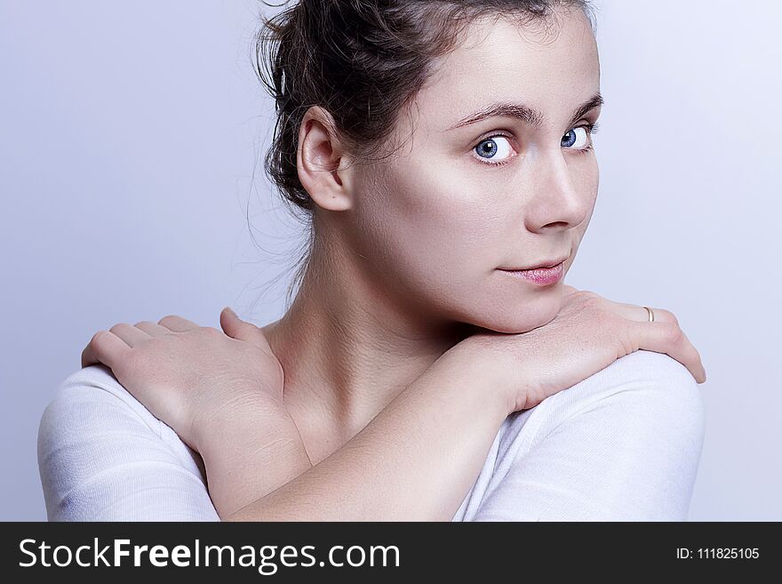 Portrait of young attractive caucasian girl on gray background. Gentle look of beautiful woman