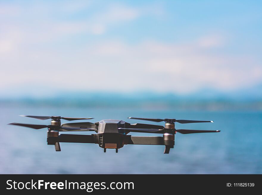 drone quad copter with high resolution digital camera flying the sky with lake view