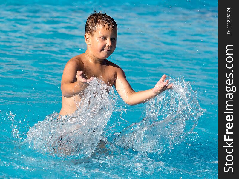 Boy swims with a splash in the water park .