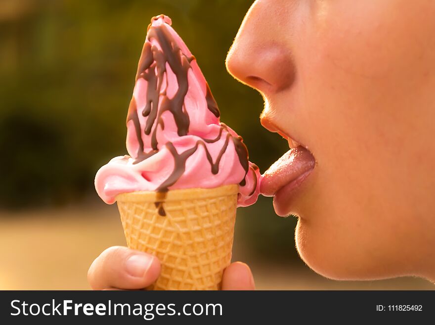 Young teenage girl eating ice cream . Ice cream strawberry with chocolate sauce. Young teenage girl eating ice cream . Ice cream strawberry with chocolate sauce.