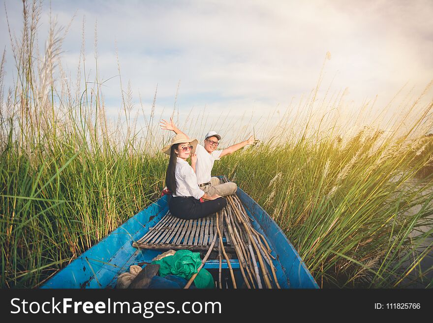 Portrait of beautiful Asian women and men sitting on fishing boat, enjoy natural outdoor at lake. Portrait of beautiful Asian women and men sitting on fishing boat, enjoy natural outdoor at lake