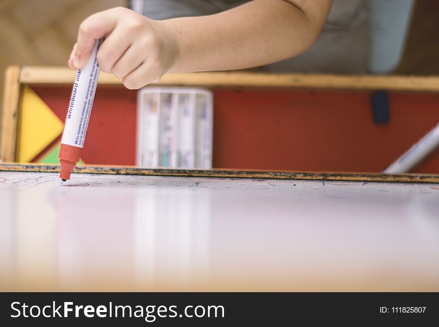 Child Holding A Pencil In Whiteboard Closeup