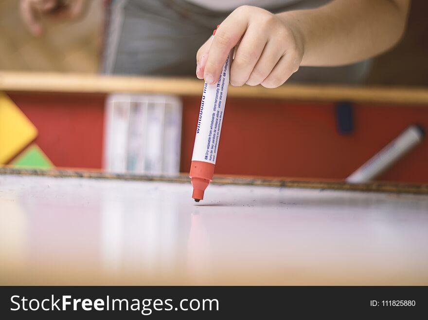 Child Holding A Pencil In Whiteboard Closeup