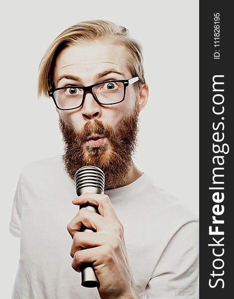 Lifestyle and people concept: young man singing with microphone, on white background