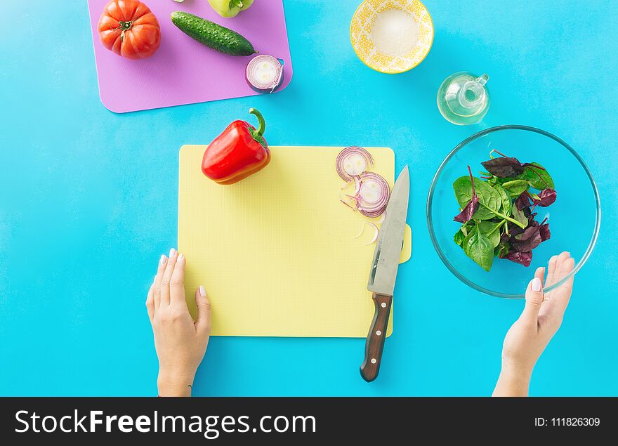 Healthy food concept. Diet food. Woman hands cooking summer vegetarian salad on blue background. Healthy food concept. Diet food. Woman hands cooking summer vegetarian salad on blue background