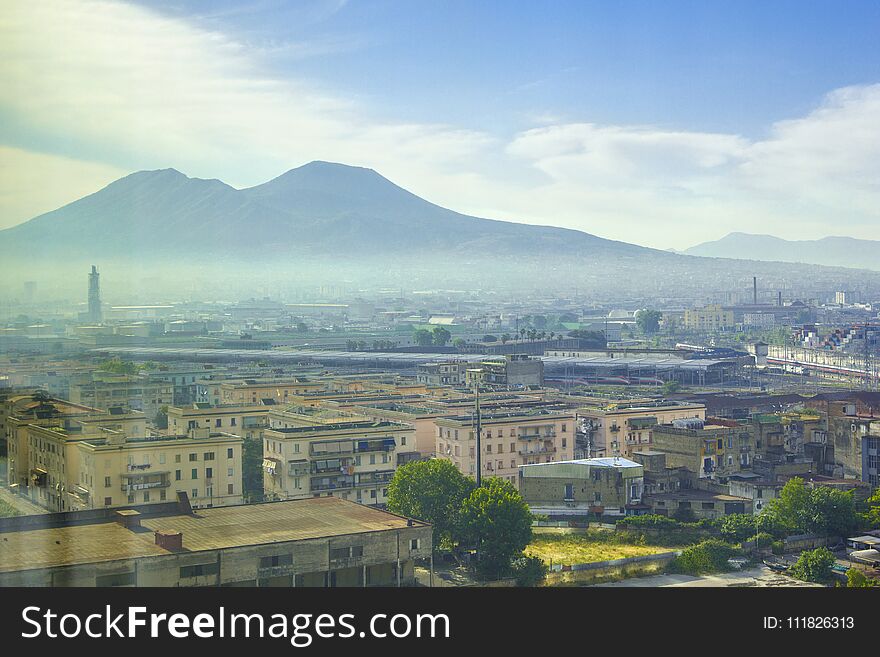 Top view of the Vesuvius volcano and the roofs of Naples` houses in the early summer morning at sunrise, Italy. Top view of the Vesuvius volcano and the roofs of Naples` houses in the early summer morning at sunrise, Italy