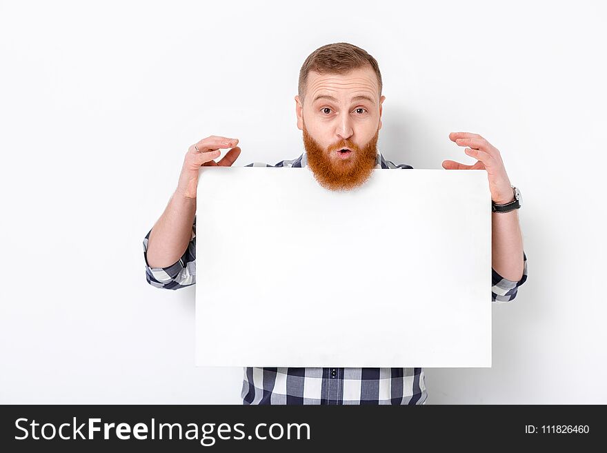 Handsome man with beard holding big white card. empty blank board