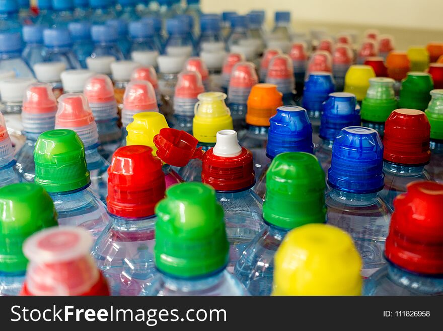 Plastic bottles with water, color caps.