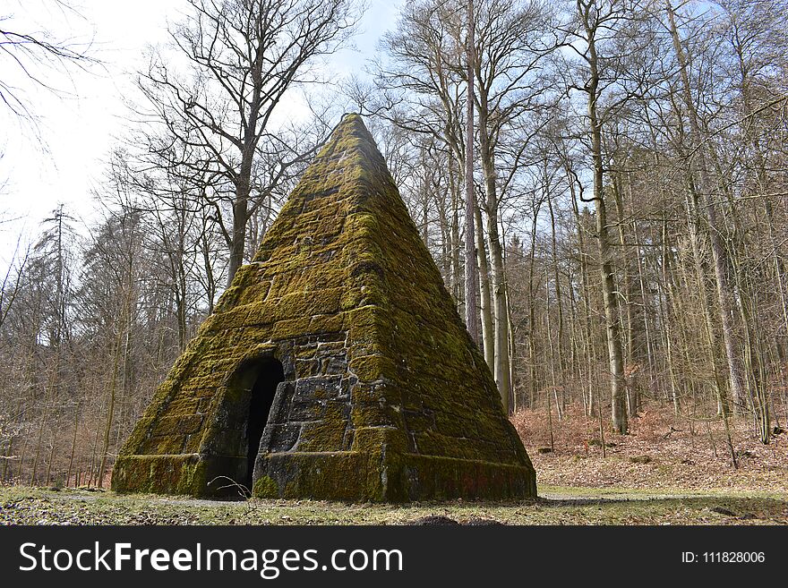 Ancient stone pyramid with moss in the forest on the way to the World Cultural Heritage Herkules in Kassel, Wilhelmshöhe in Germany