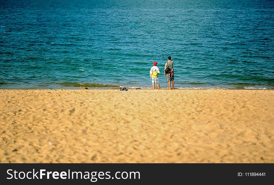 Two Persons Standing Near Beach