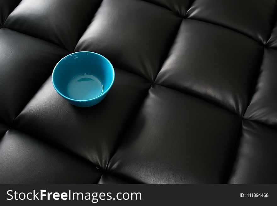 Blue Ceramic Bowl on Black Leather Surface