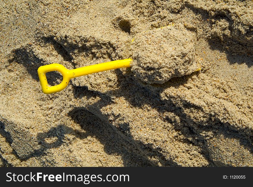 Yellow sand shovel on beach. Yellow sand shovel on beach