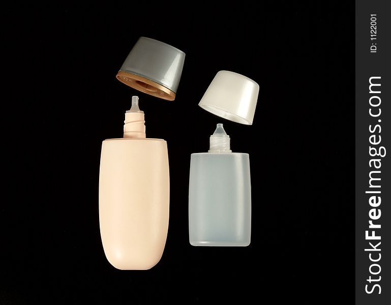 Empty small plastic bottles for cosmetics on solid black background