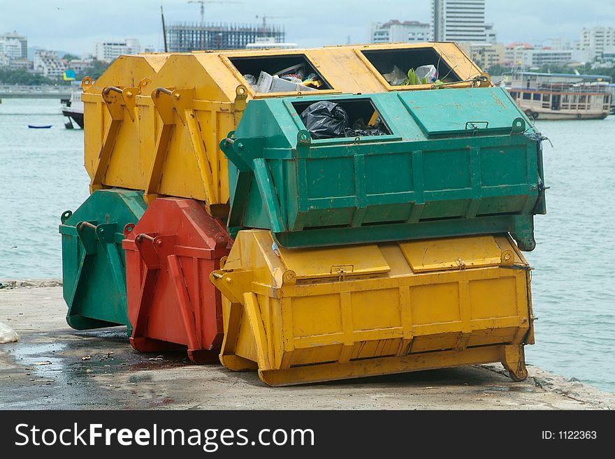 Six garbage containers, yellow, green and red.