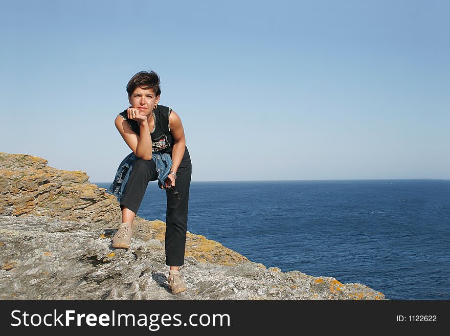 Woman on a cliff  looking at the sea. Woman on a cliff  looking at the sea