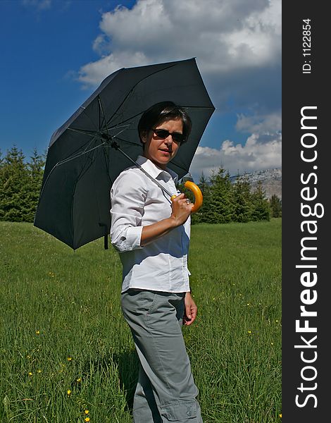 Woman going in a meadow with its umbrella. Woman going in a meadow with its umbrella