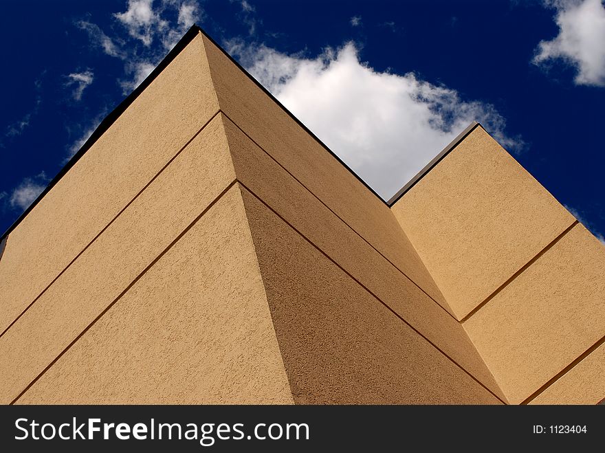 Photo of corner of building showing blue sky and clouds. Photo of corner of building showing blue sky and clouds.