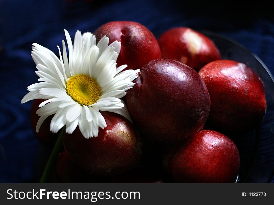 The plate, full fruits with a camomile. The plate, full fruits with a camomile