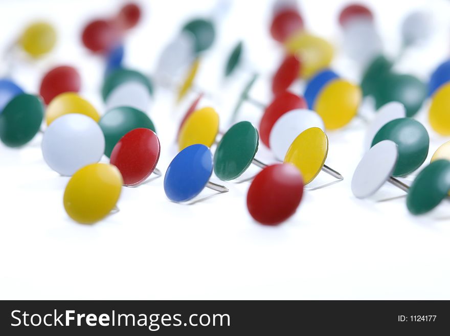 A number of colorful thumbtacks isolated on white