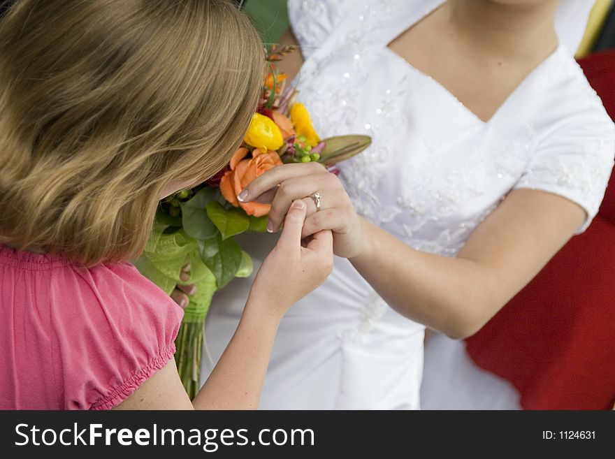 A little girl admires her older sister's wedding ring. A little girl admires her older sister's wedding ring.