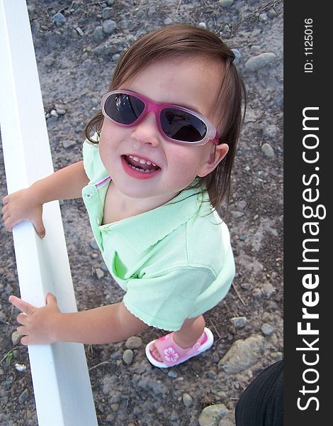 Little girl smiling with sunglasses. Little girl smiling with sunglasses