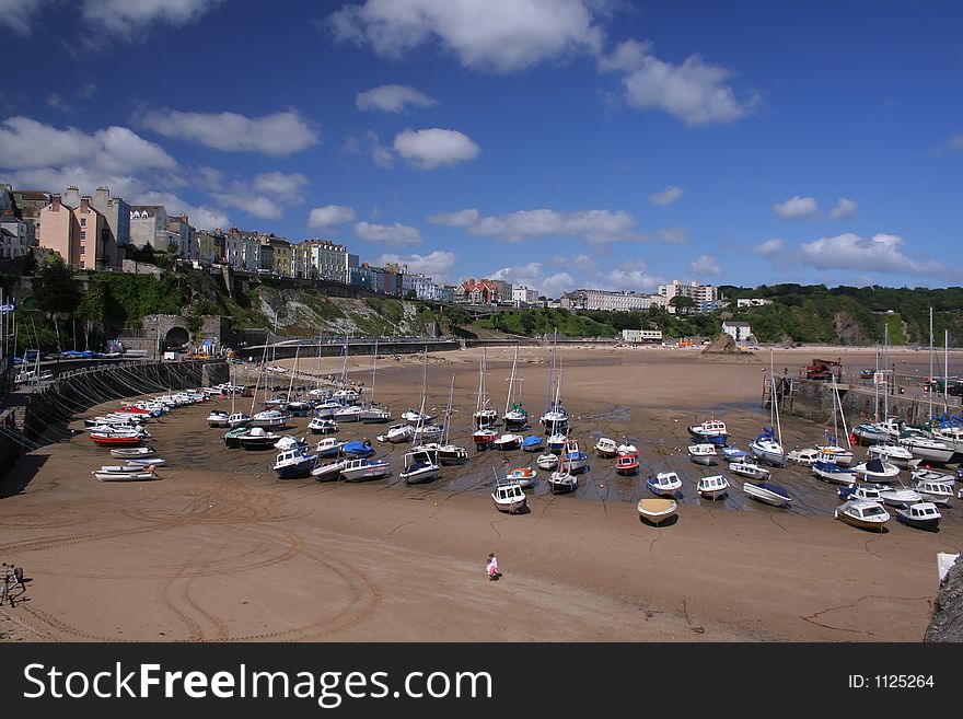 Boats on the sand at low tide on Tenby beach, Wales, UK. Boats on the sand at low tide on Tenby beach, Wales, UK