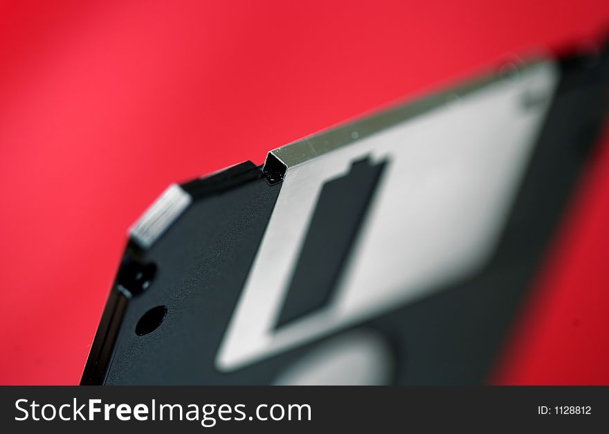 Old computer disk diskette on red background