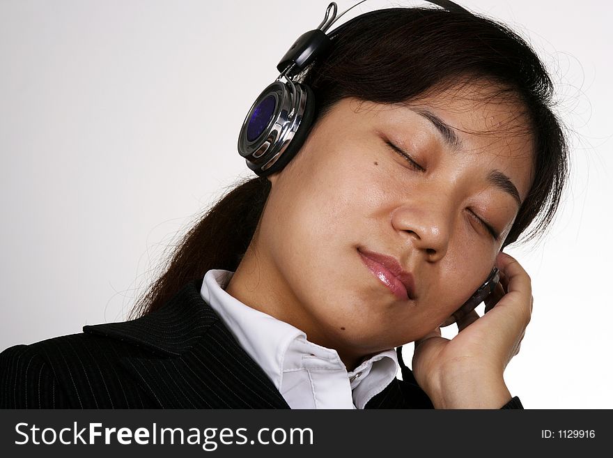 Asian businesswoman listening music in the office