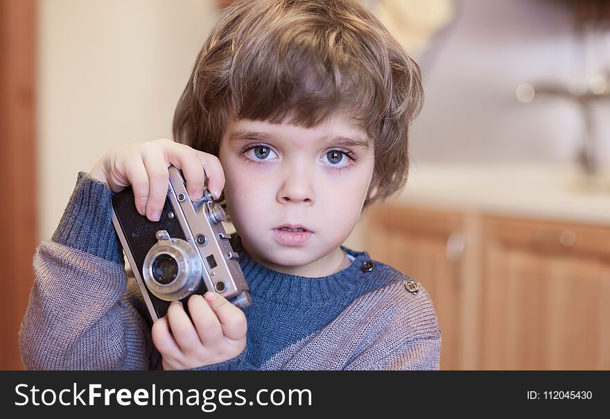 Beautiful little boy, has happy fun smiling face, big pretty eyes, long eyelashes, holds camera. Child portrait. Creative concept. Close up. Fashion style boy. Amazing people. Selfie style fashion. Beautiful little boy, has happy fun smiling face, big pretty eyes, long eyelashes, holds camera. Child portrait. Creative concept. Close up. Fashion style boy. Amazing people. Selfie style fashion.