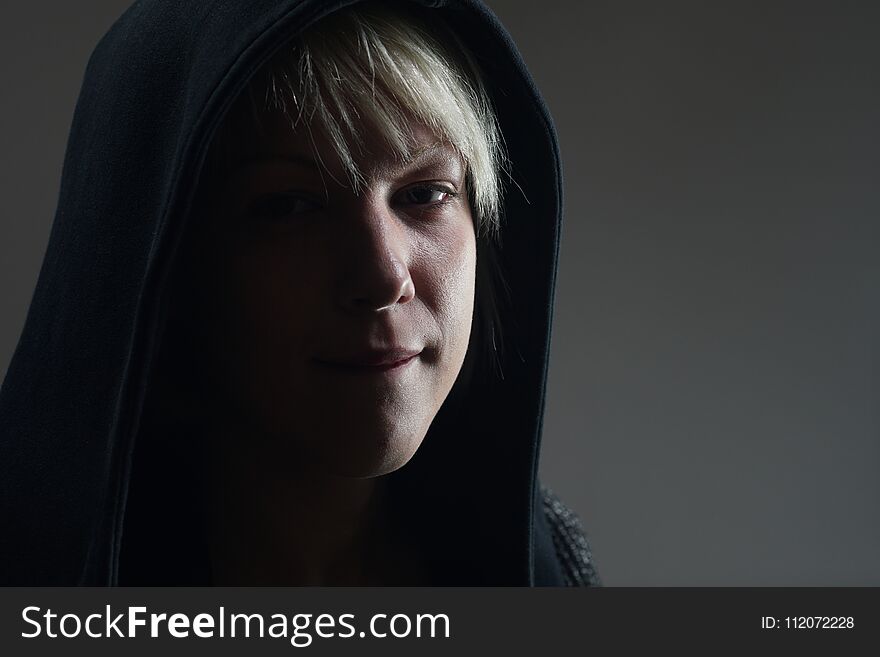 Young blonde girl portrait with a black hoodie, expression full of awareness