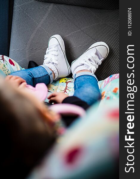 Cute white shoes on baby girl, detail, blurred, blue jeans, perspective