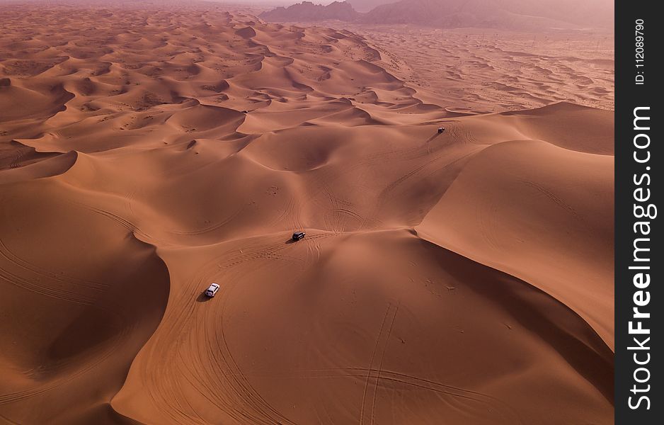 Two Vehicles on Desert Dunes