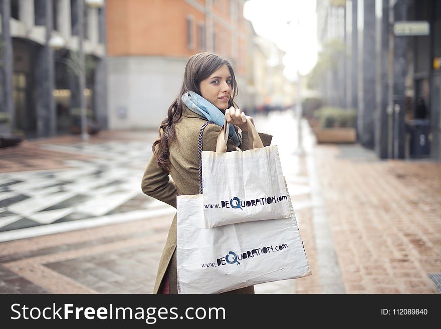 Woman in Brown Coat Carrying Two White Tote Bags