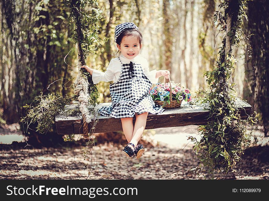 Girl in Black and White Overall Skirt Holding Basket With Petaled Flowers
