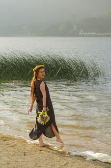 Young Woman With Yellow Flowers In Her Hand At The Lake Shore, L Royalty Free Stock Photos