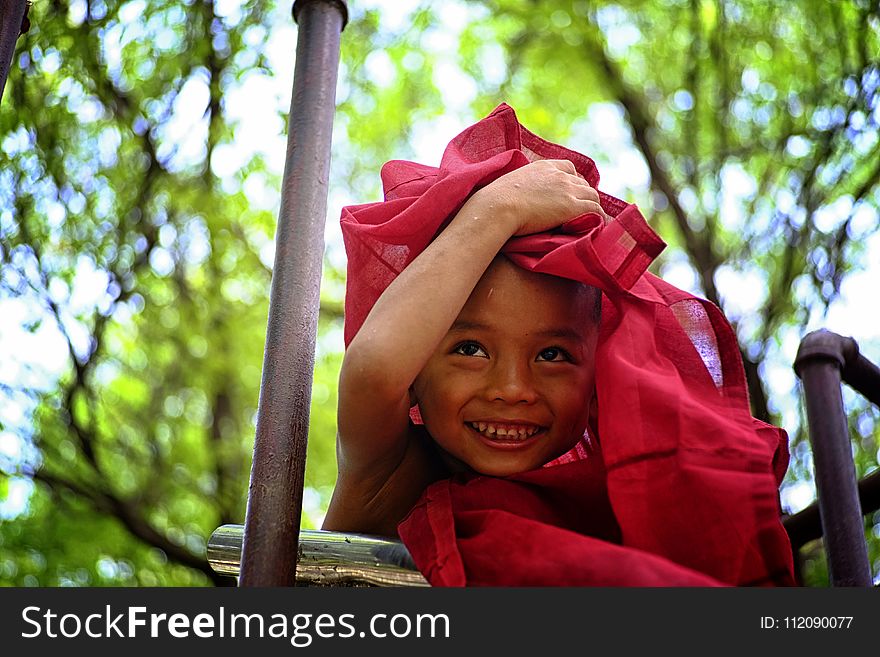 Boy Holding Red Textile Covering His Head