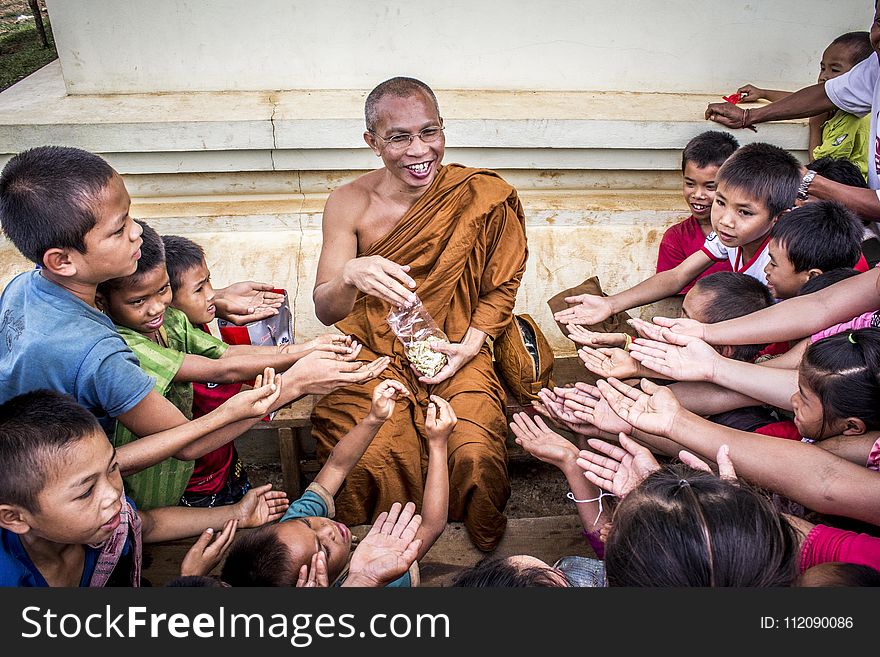 Man in Monk Dress Between Group of Children