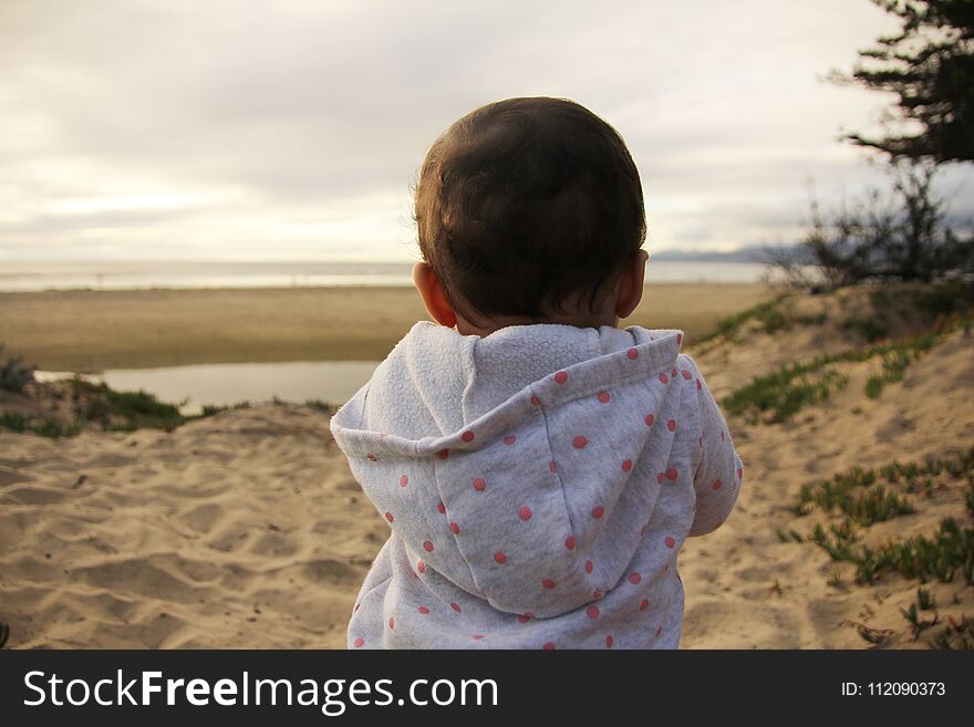 Baby playing on the beach.