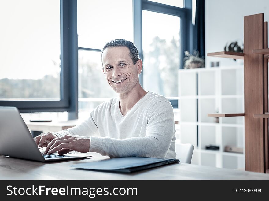 Successful Qualified Man Smiling And Using The Laptop.