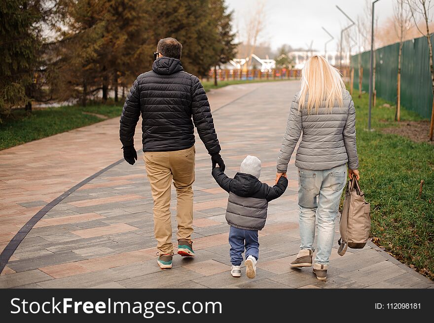 Young family couple walking the handle with a son