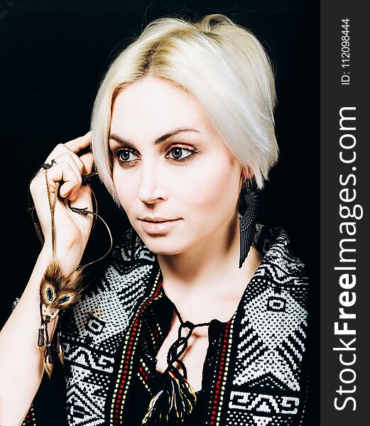 A portrait of a young pretty blonde on a black background in studio. A portrait of a young pretty blonde on a black background in studio