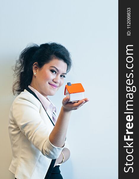 Woman Looks And Holds A House Model On White Background