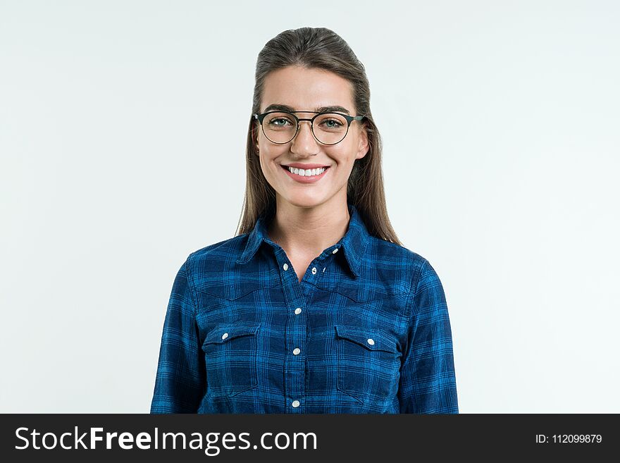 Portrait of young positive woman with long straight hair, blue eyes and an attractive smile, posing in the studio on white background. People, happiness, emotions and way of life