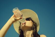Young Girl Is Drinking Water On The Blue Sky Background. Stock Photography
