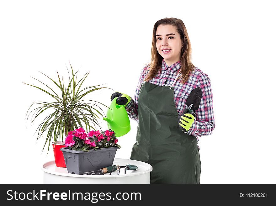 Portrait of smiling woman professional gardener or florist in apron holding flowers in a pot and gardening tools isolated on white background