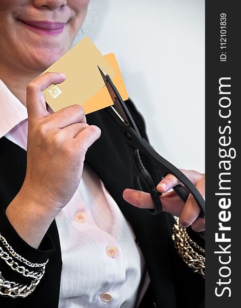 Woman is cutting two credit cards by a scissor in her hand. Woman is cutting two credit cards by a scissor in her hand