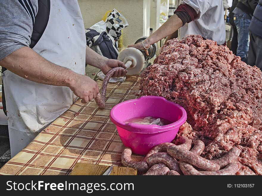 The butcher makes homemade sausages in the open air in a traditional way. The butcher makes homemade sausages in the open air in a traditional way.