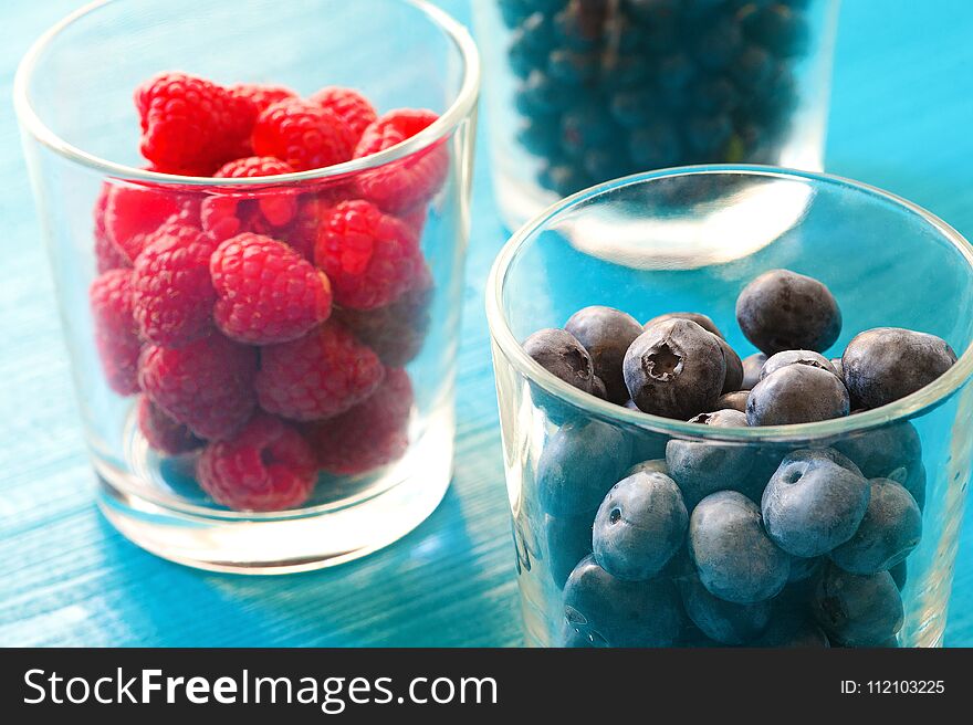 A three bowls overflowing with summer berries like raspberries, blueberries. A three bowls overflowing with summer berries like raspberries, blueberries