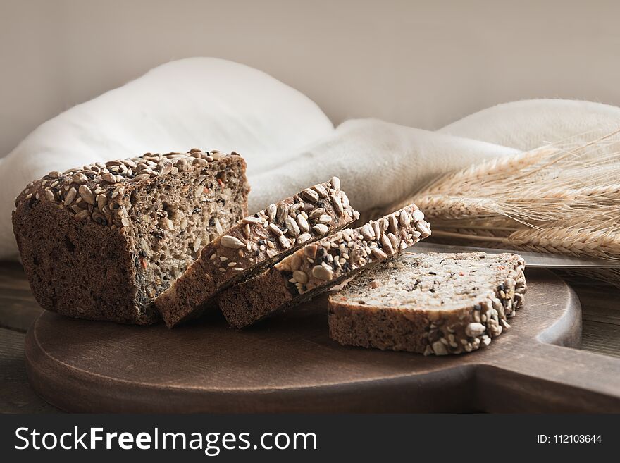 A Loaf Of Fresh Rustic Rye Bread On Wooden Board. Healphy Food Background. Close Up. Copy Space. Fitness Wholegrain