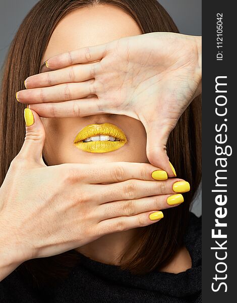 Woman face. Yellow nail. Blue lips. Close up Isolated beauty portrait.